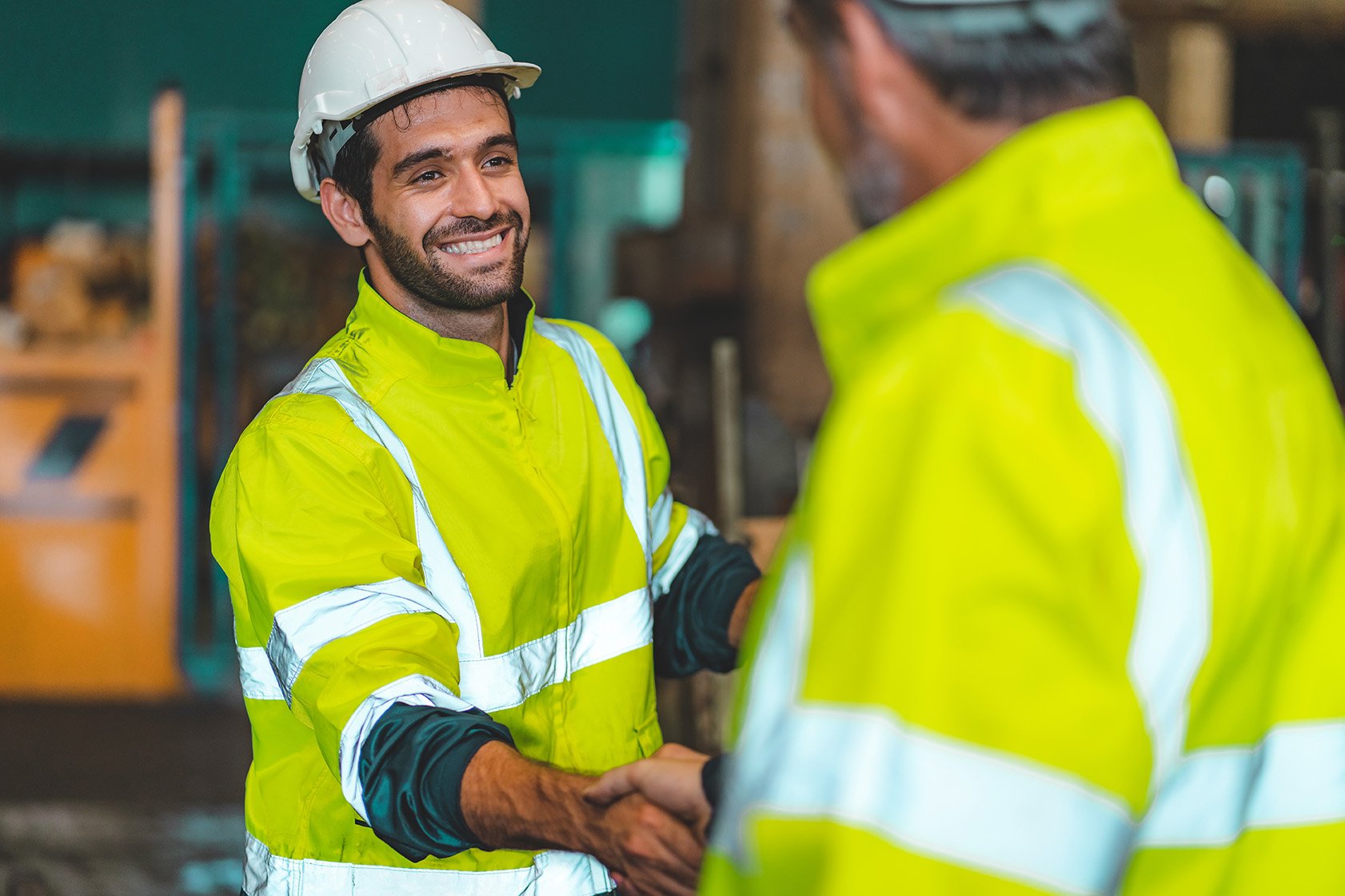 Caucasian factory engineer talking and shaking hands on business cooperation agreement