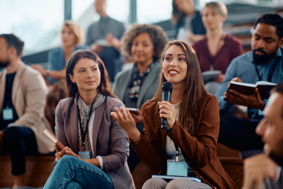 A diverse group of people engaged in discussion in a well-lit conference room.