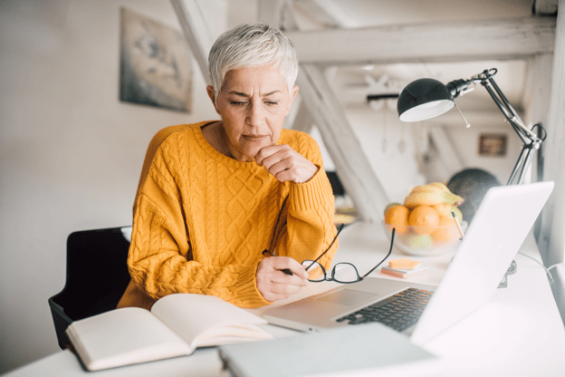 A woman sitting at her work computer deep in thought