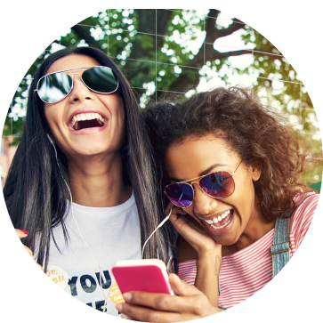 Image of two women outside listening to music and laughing