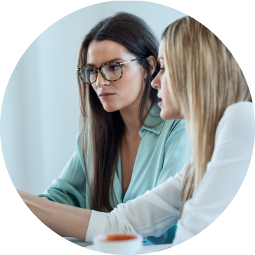 Two women sitting at a desk in an office